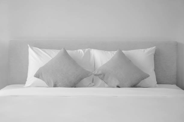 A neatly made bed with pillows and a top sheet emphasizes the importance of this additional bedding layer.